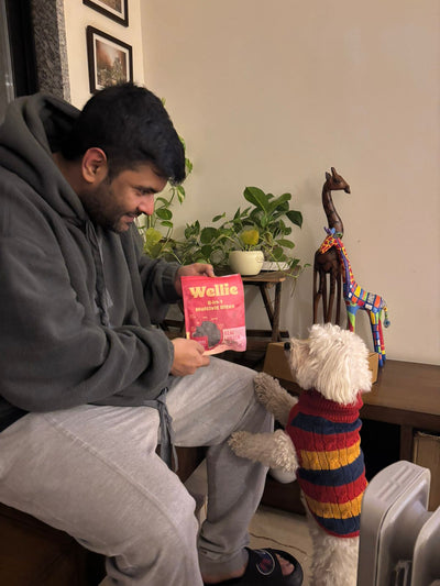 Man with Wellie Multivit Bites and a dog wearing a colorful sweater in a home setting.